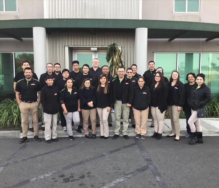 Team of SERVPRO professionals in front of a building.